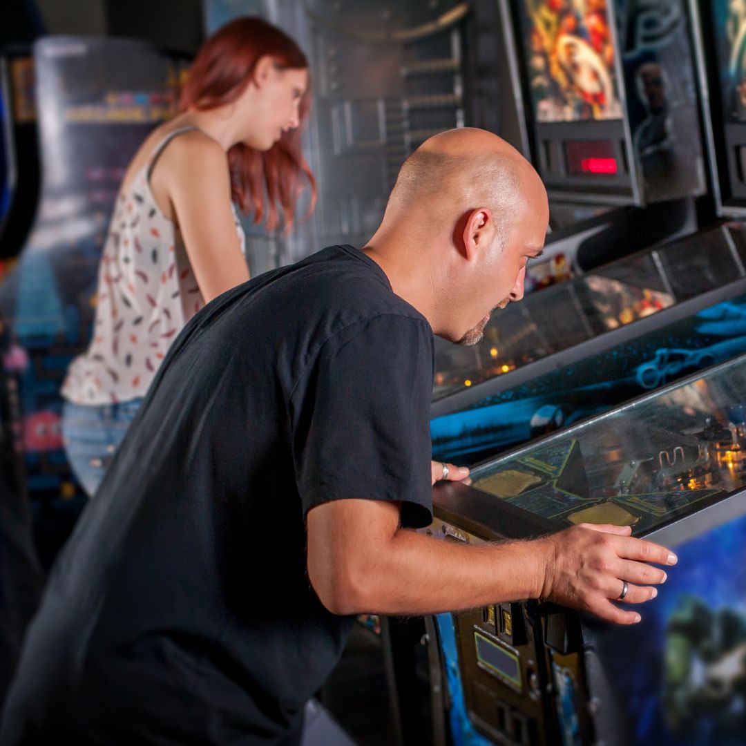 man and woman playing games at arcade