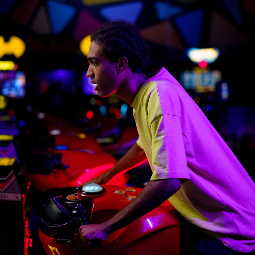Young teen playing arcade game