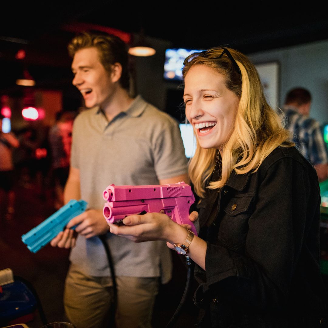 man and woman playing arcade game