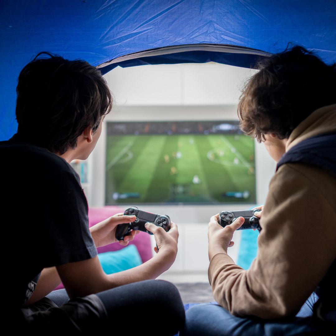 Two young men playing a console game against each other. 